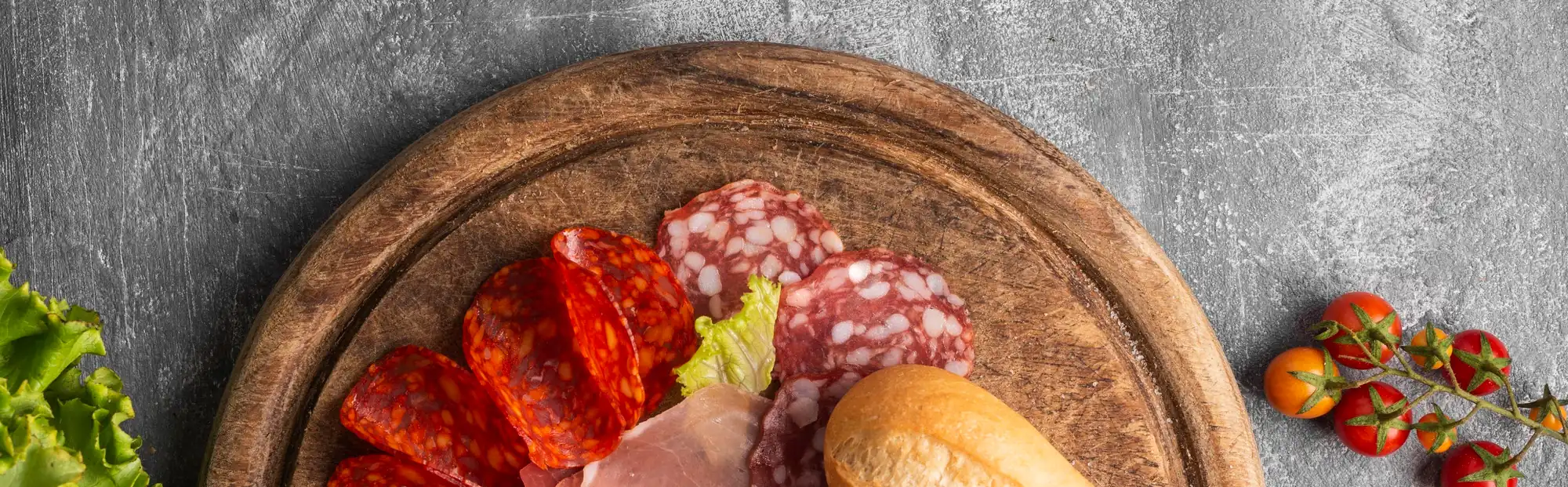 Tabla de charcutería con salame, jamón y pan, vista desde arriba