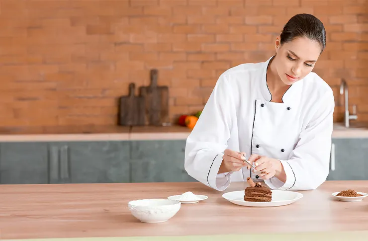 Chef pastelera terminando una pieza de chocolate en su cocina