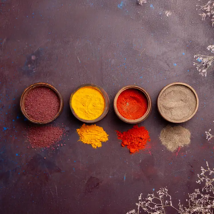 Pigmentos naturales en polvo en tonos rojo, ocre y carmesí, en recipientes pequeños